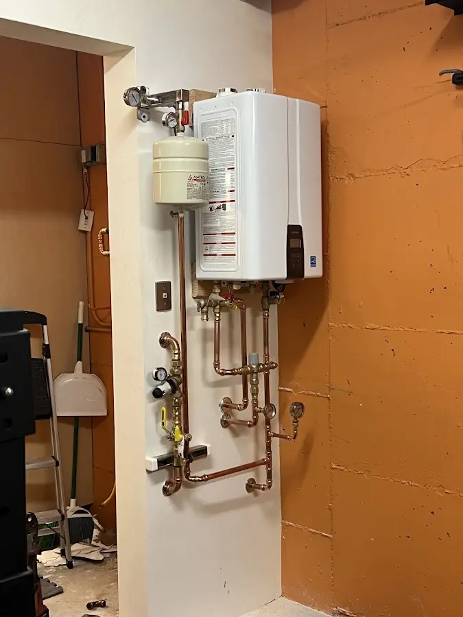 Plumbing technician inspecting water heater connections in Sylvania